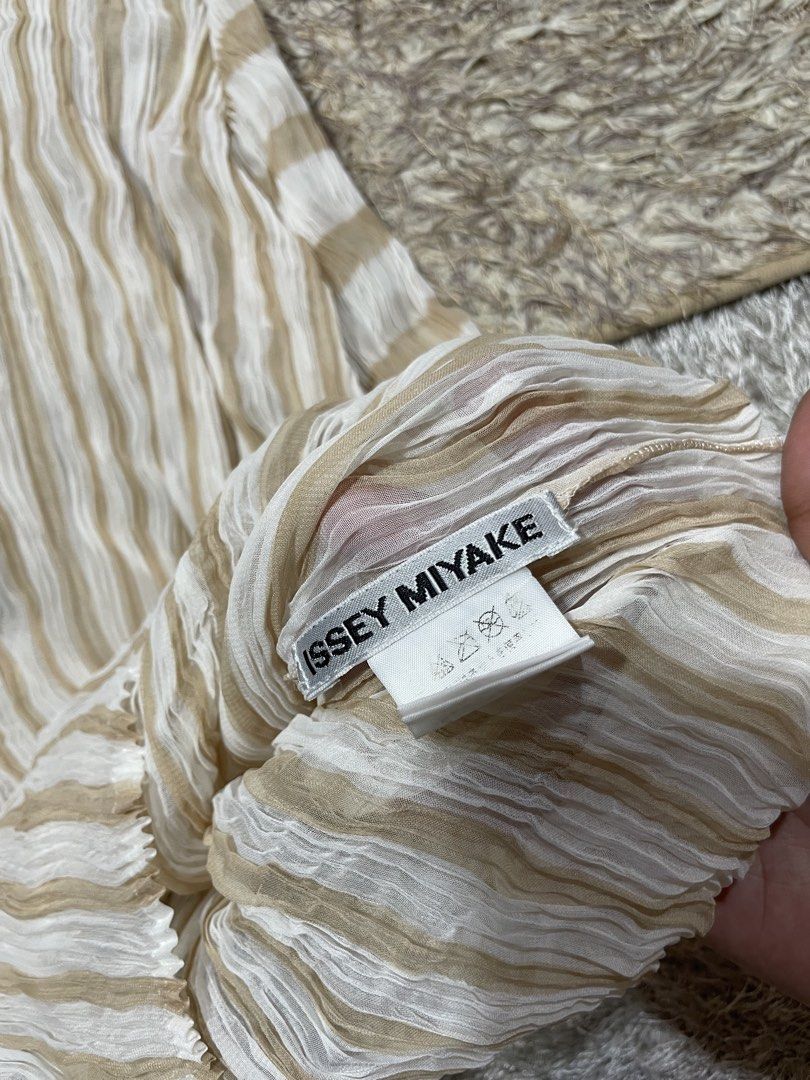 Issey Miyake Top (Category: Luxury Apparel) located in Manila. Submitted by rutchemari68583 (Listing ID 1460768628, Image 3). Description: - Authentic Issey Miyake top - Beige and white striped pattern - Signature Issey Miyake pleats - High neckline and long sleeves - Unique, textured fabric - Versatile for layering or standalone wear - Classic designer piece.