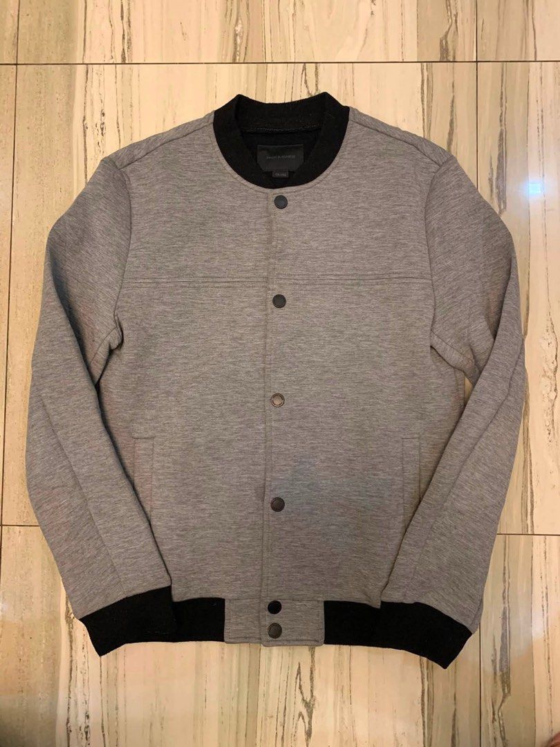Jack & Jones Grey Bomber Jacket (Category: Coats, Jackets and Outerwear) located in Manila. Submitted by vintaurafindsco. (Listing ID 1460882646, Image 1). Description: - Jack & Jones Grey Bomber Jacket - Black collar and cuffs - Button-up front - Two side pockets - Estimated size: Medium (M) - Ideal for casual wear.