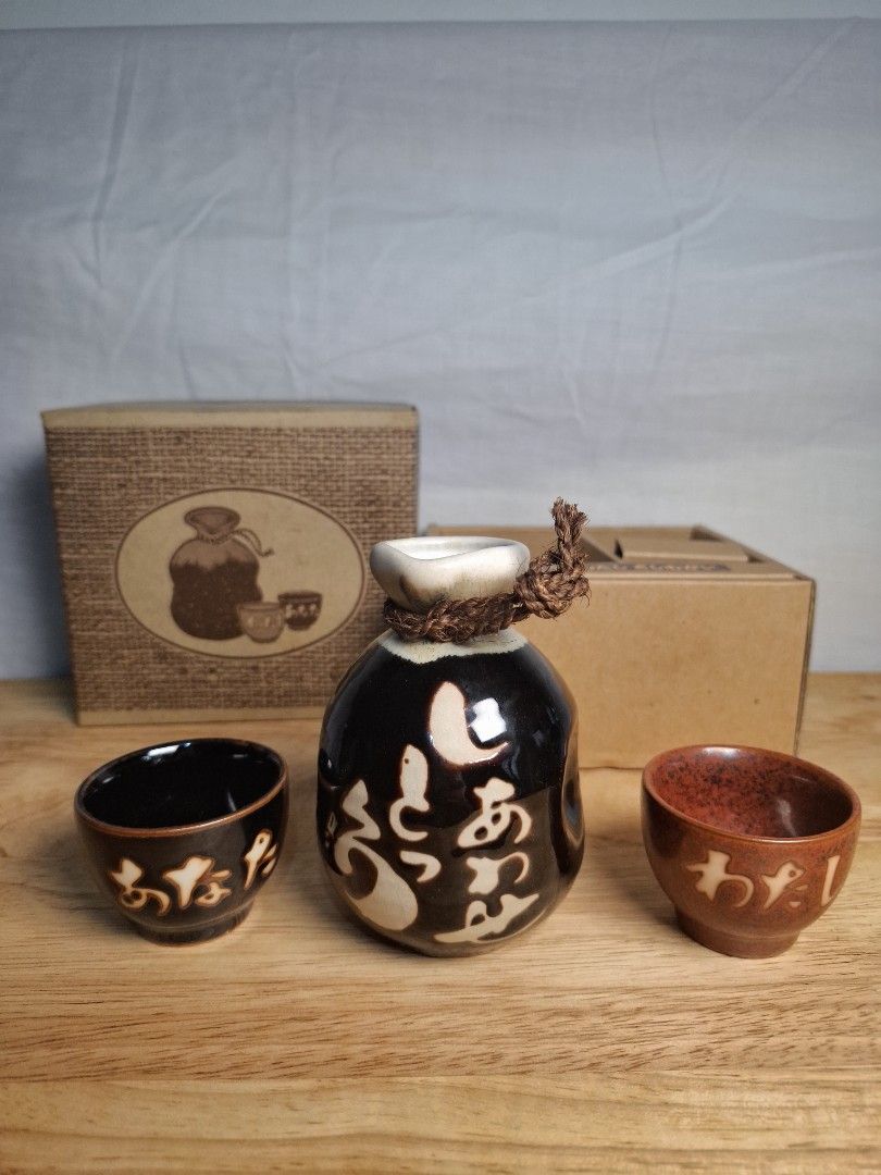 Japanese Sake Set with Flask and Cups (Category: Coffee & Tea Tableware) located in Mandaluyong City. Submitted by edward123_andren (Listing ID 1460911742, Image 1). Description: - Includes one sake flask and two cups. - Flask is black with white designs. - Cups are brown. - Presented in an attractive gift box. - Perfect for enjoying sake, gifting, or personal collection..
