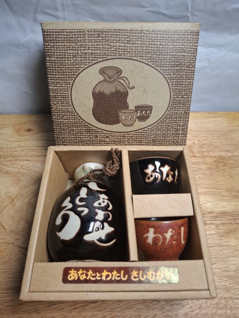 Japanese Sake Set with Flask and Cups (Category: Coffee & Tea Tableware) located in Mandaluyong City. Submitted by edward123_andren (Listing ID 1460911742, Image 2). Description: - Includes one sake flask and two cups. - Flask is black with white designs. - Cups are brown. - Presented in an attractive gift box. - Perfect for enjoying sake, gifting, or personal collection..