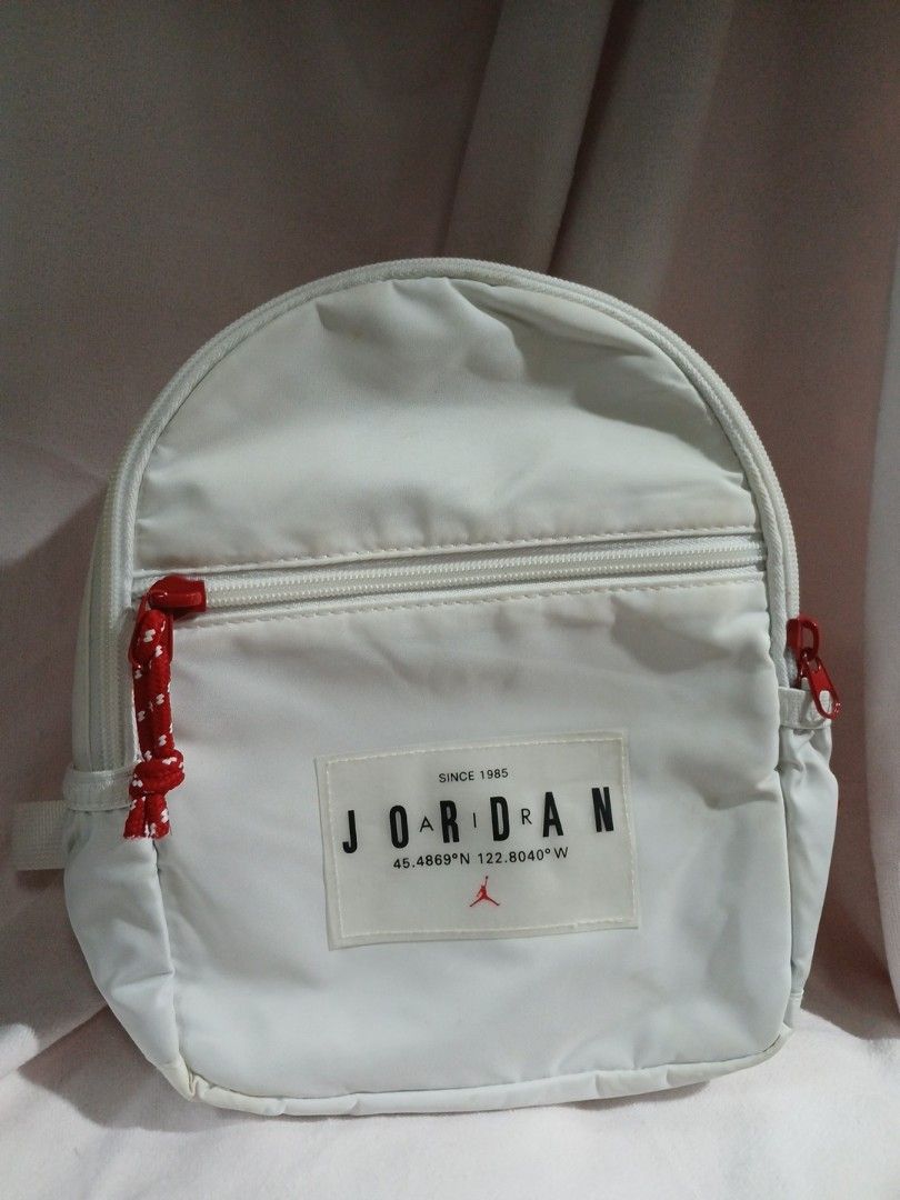 Jordan Mini Bag (Category: Backpacks) located in La Trinidad. Submitted by dashopperist (Listing ID 1460785113, Image 1). Description: - White Jordan mini backpack - Adjustable straps - Front zip pocket - Side Jordan logo detail - Made of durable polyester - Compact size: 203mm x 102mm x 254mm - Ideal for carrying your daily essentials.