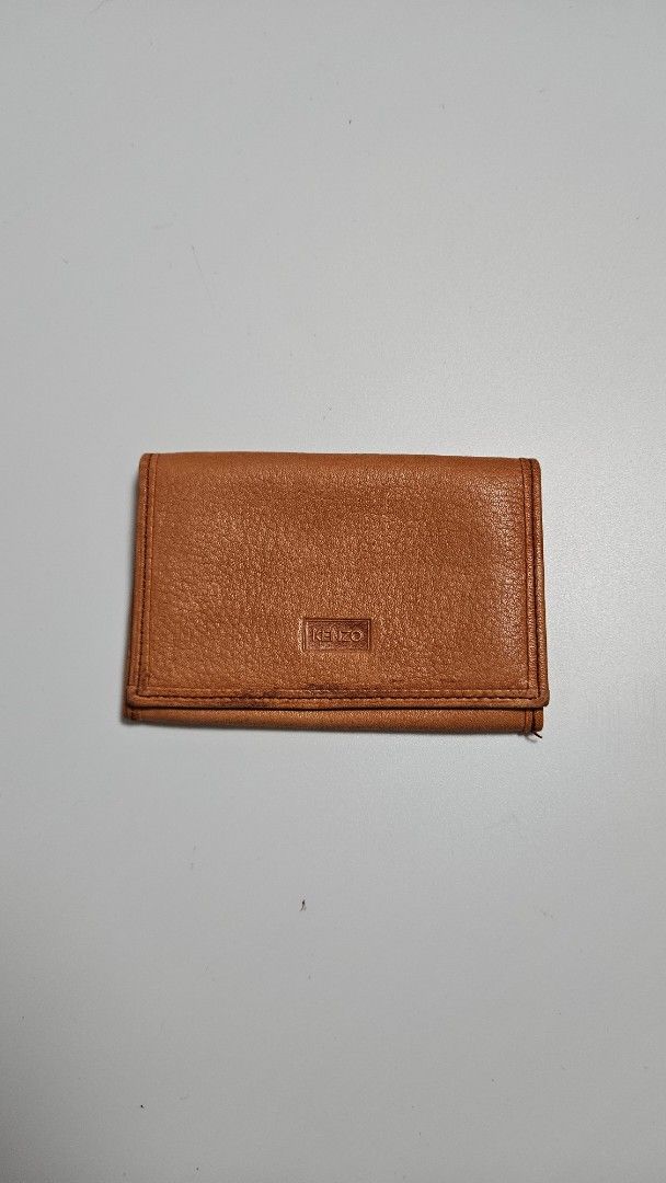 KENZO Brown Leather Bifold Wallet (Category: Luxury Bags & Wallets) located in Alfonso. Submitted by jbcamet (Listing ID 1460828383, Image 1). Description: - Brand: KENZO - Material: Brown Leather - Exterior: Textured with embossed logo - Interior: Card slots - Style: Classic bifold, perfect for everyday use.