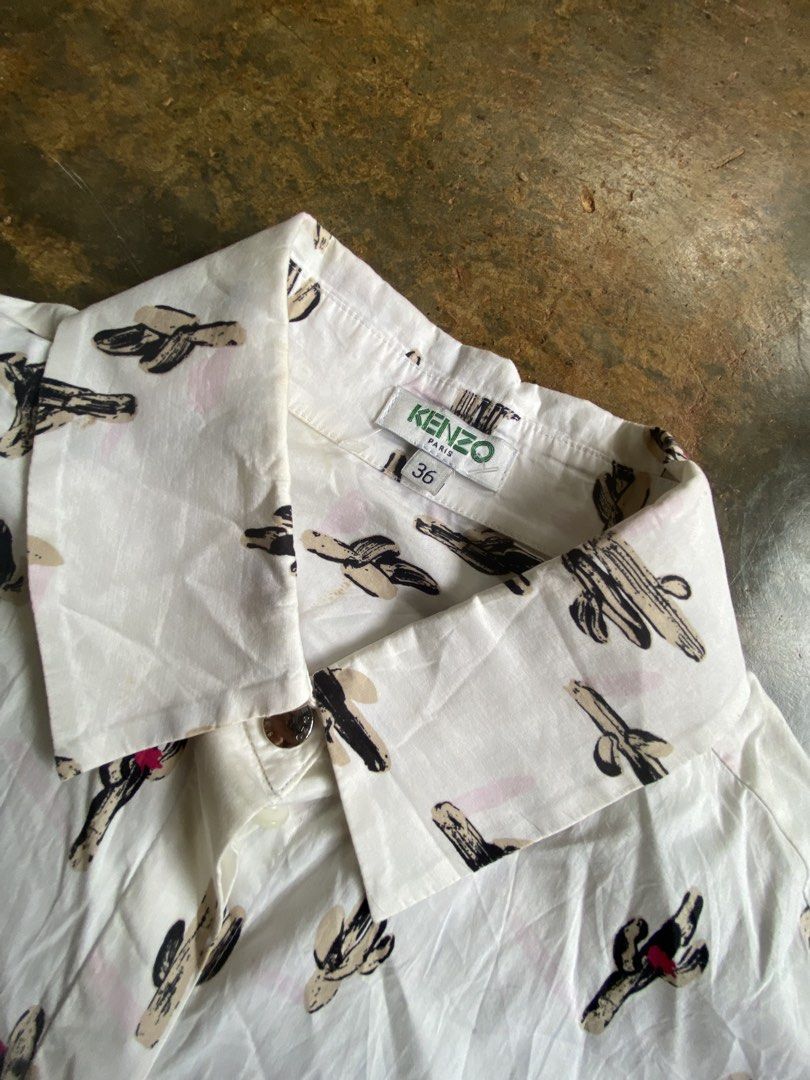 Kenzo Cactus Buttondown Long Sleeve (Category: Luxury Apparel) located in Dapitan. Submitted by bolandojh07634 (Listing ID 1460864530, Image 2). Description: - White long sleeve shirt -Size large to XL - All-over fun cactus print - Button-up front closure - Single chest pocket - Slight high-low hemline - Ideal for casual and quirky styling - Pairs well with jeans or shorts.