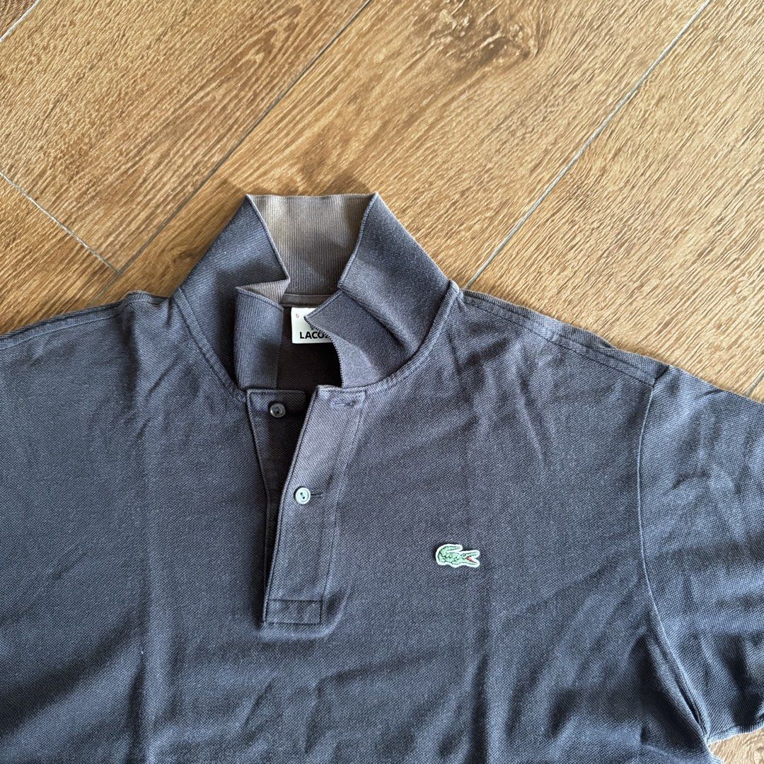 Lacoste Black Polo Shirt (Category: Tshirts & Polo Shirts ) located in Manila. Submitted by juddscloset (Listing ID 1460770668, Image 2). Description: Lacoste polo shirt, black, embroidered crocodile logo on chest. Preloved, from my own closet. Measured: Chest 21in flat/~42in circumference | Length 26in | Sleeve opening 6.25in issue: color is fading to brown especially in collar area. fading makes it look vintage imo.