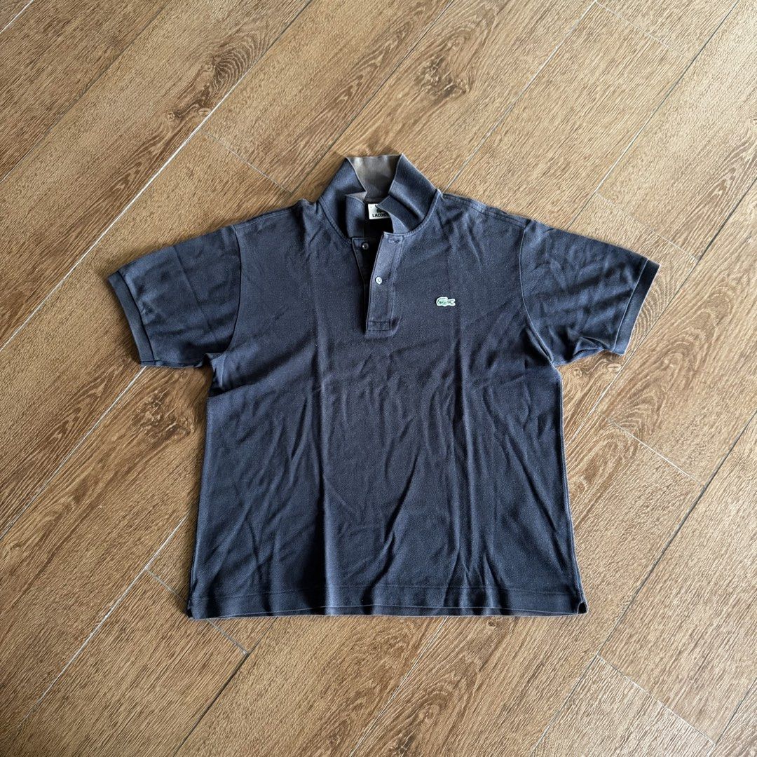 Lacoste Black Polo Shirt (Category: Tshirts & Polo Shirts ) located in Manila. Submitted by juddscloset (Listing ID 1460770668, Image 1). Description: Lacoste polo shirt, black, embroidered crocodile logo on chest. Preloved, from my own closet. Measured: Chest 21in flat/~42in circumference | Length 26in | Sleeve opening 6.25in issue: color is fading to brown especially in collar area. fading makes it look vintage imo.