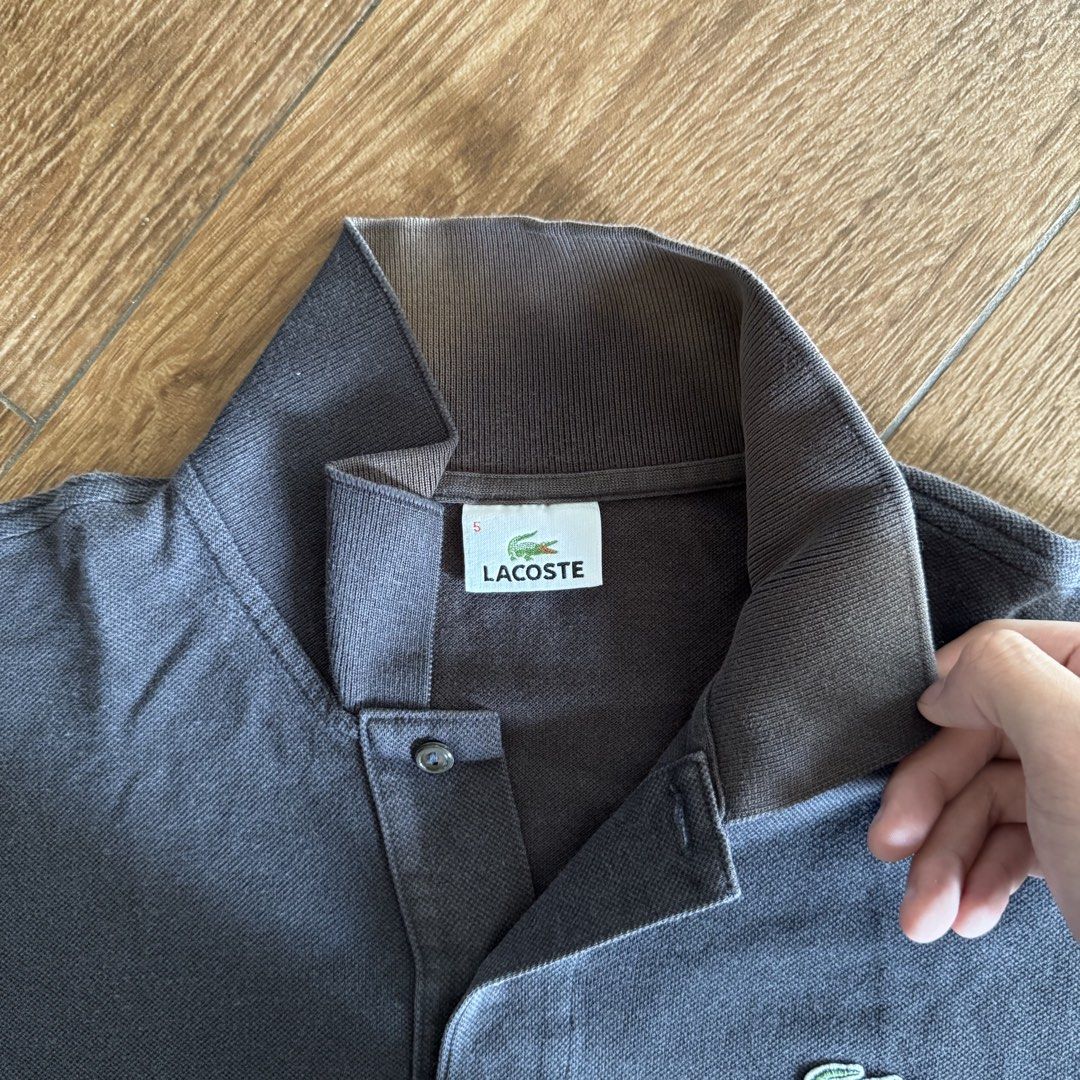Lacoste Black Polo Shirt (Category: Tshirts & Polo Shirts ) located in Manila. Submitted by juddscloset (Listing ID 1460770668, Image 3). Description: Lacoste polo shirt, black, embroidered crocodile logo on chest. Preloved, from my own closet. Measured: Chest 21in flat/~42in circumference | Length 26in | Sleeve opening 6.25in issue: color is fading to brown especially in collar area. fading makes it look vintage imo.