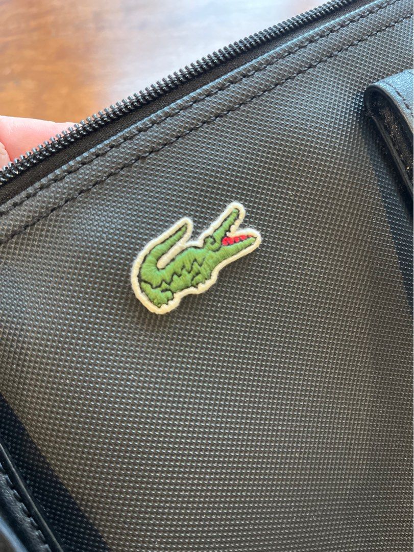 Lacoste Black Tote Bag with Crocodile Logo (Category: Tote Bags) located in Makati City. Submitted by apwellloved (Listing ID 1460779841, Image 2). Description: - Authentic Classic black Lacoste tote bag - Features iconic green crocodile logo - Made with durable material - Genuine leather handles - Secure zip closure - Interior zip pocket for essentials - Stylish and perfect for everyday use.