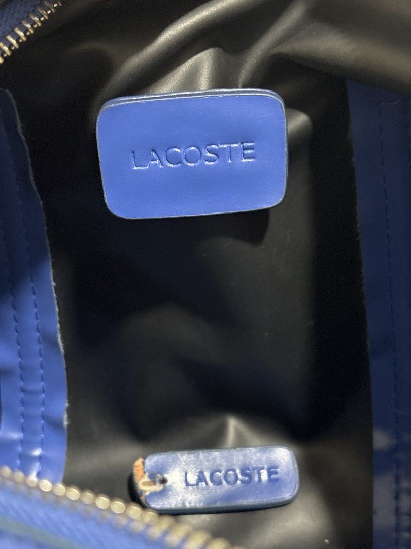 Lacoste Blue Nylon Bag with Shoulder Strap (Category: Shoulder Bags) located in Quezon City. Submitted by chandria123 (Listing ID 1460803796, Image 3). Description: - Cobalt Blue Lacoste small duffle bag - Durable nylon material -Silver hardware - Detachable shoulder strap included - Interior pocket for organization - Ideal size for daily use can store a lot - Minor stain on the side - Small tear on the bottom - Zippers are fully functional -Zipp