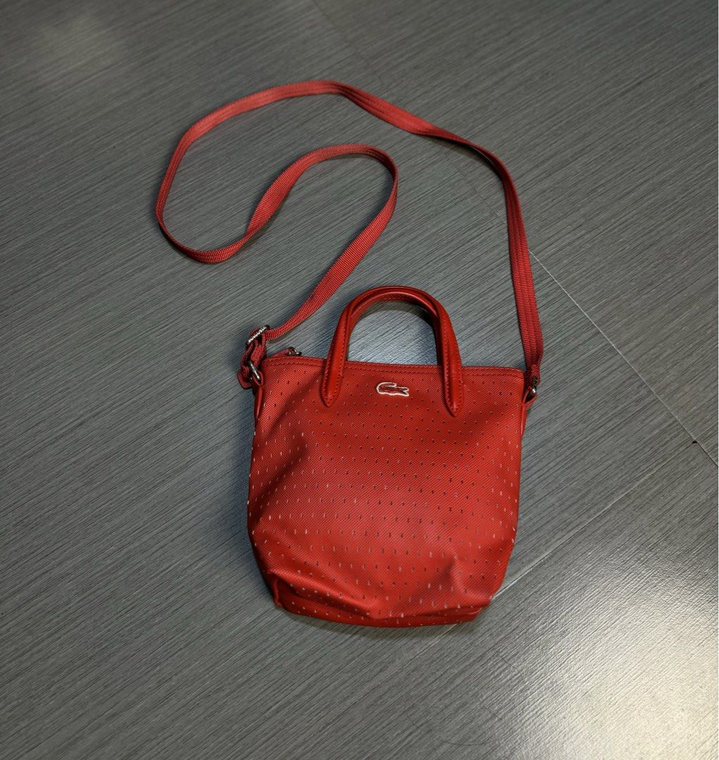 Lacoste Red Perforated Tote Bag with Strap (Category: Shoulder Bags) located in Manila. Submitted by mzcollection_349 (Listing ID 1460722456, Image 1). Description: - Authentic Red Lacoste tote bag - Stylish perforated design all over - Comfortable top handles - Includes a detachable crossbody strap for versatile wear - Secure zipper closure - Small tag detail and interior tag for authenticity - Ideal for everyday use.