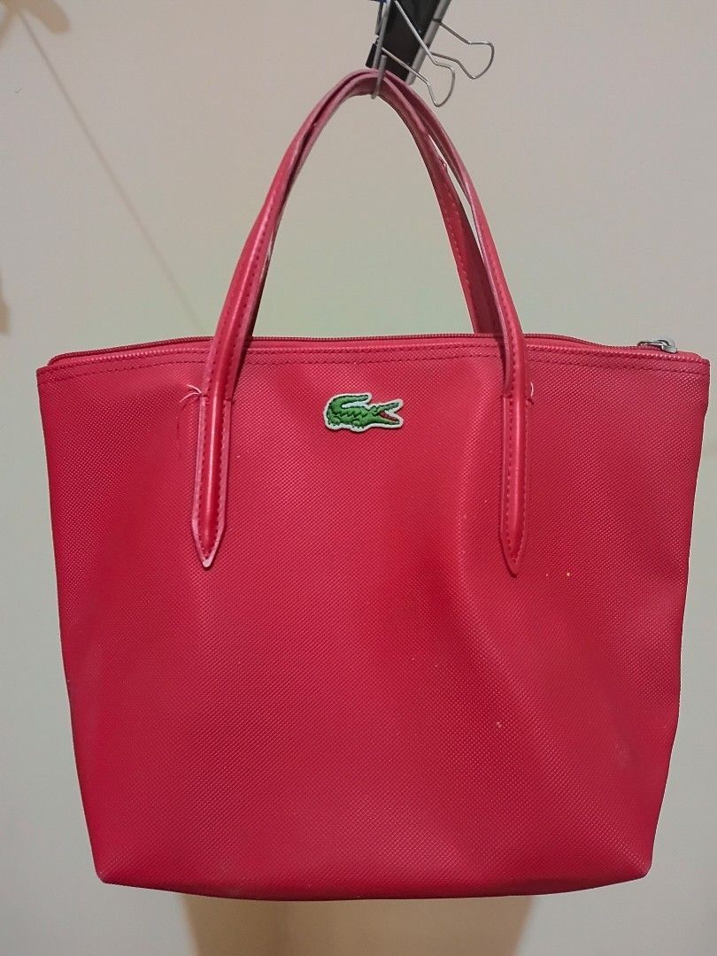 Lacoste Red Tote Bag (Category: Tote Bags) located in Cavite. Submitted by ms.de.clutter (Listing ID 1460790761, Image 1). Description: - Red Lacoste tote bag - Signature crocodile logo on the front - Interior zippered pocket - Small interior pouch - Handles show some wear - Ideal for everyday use.