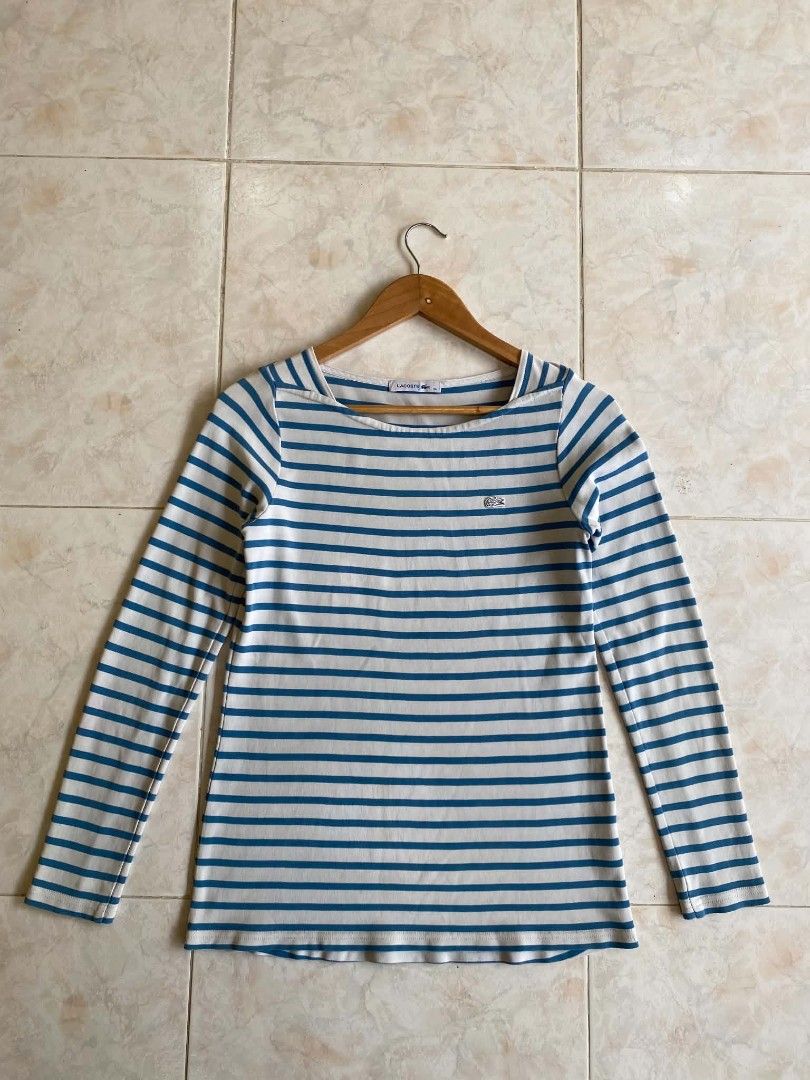 Lacoste striped long sleeve (Category: Longsleeves) located in Naga. Submitted by jadeyy-thriftcuration724 (Listing ID 1460768083, Image 2). Description: Pattern: Horizontal blue and off-white stripes. Neckline: A wide, slightly curved boat neck (or bateau neckline). Branding: The iconic embroidered Lacoste crocodile logo on the left chest.