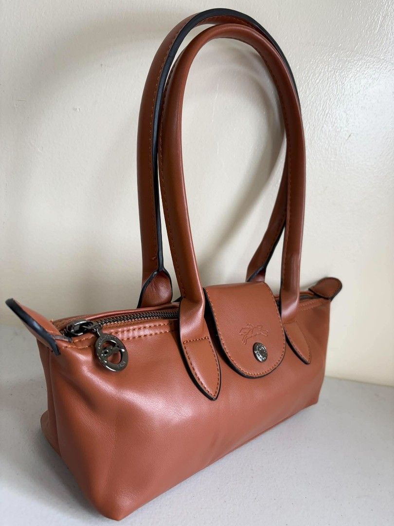 Longchamp Le Pliage Cuir Top Handle Bag (Category: Luxury Bags & Wallets) located in Manila. Submitted by ukaygandamo (Listing ID 1460732459, Image 2). Description: - Longchamp handbag - Beautiful tan leather - Top zip closure with snap tab - Interior zippered pocket - Made in France - Ideal for everyday or special occasions - Clean inside and out - Comes with dust bag.