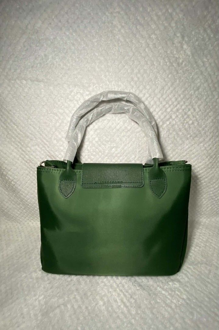 Longchamp Le Pliage Green Top Handle Bag (Category: Luxury Bags & Wallets) located in Baguio. Submitted by leah_rodrigo (Listing ID 1460760539, Image 3). Description: Authentic Green Longchamp Le Pliage Small Top Handle Bag. Nylon with leather trim. Detachable strap included. Handles still have protective plastic. Perfect for everyday. brand new plus dustbag and plastic. has crossbody straps included can be crossbody bag.