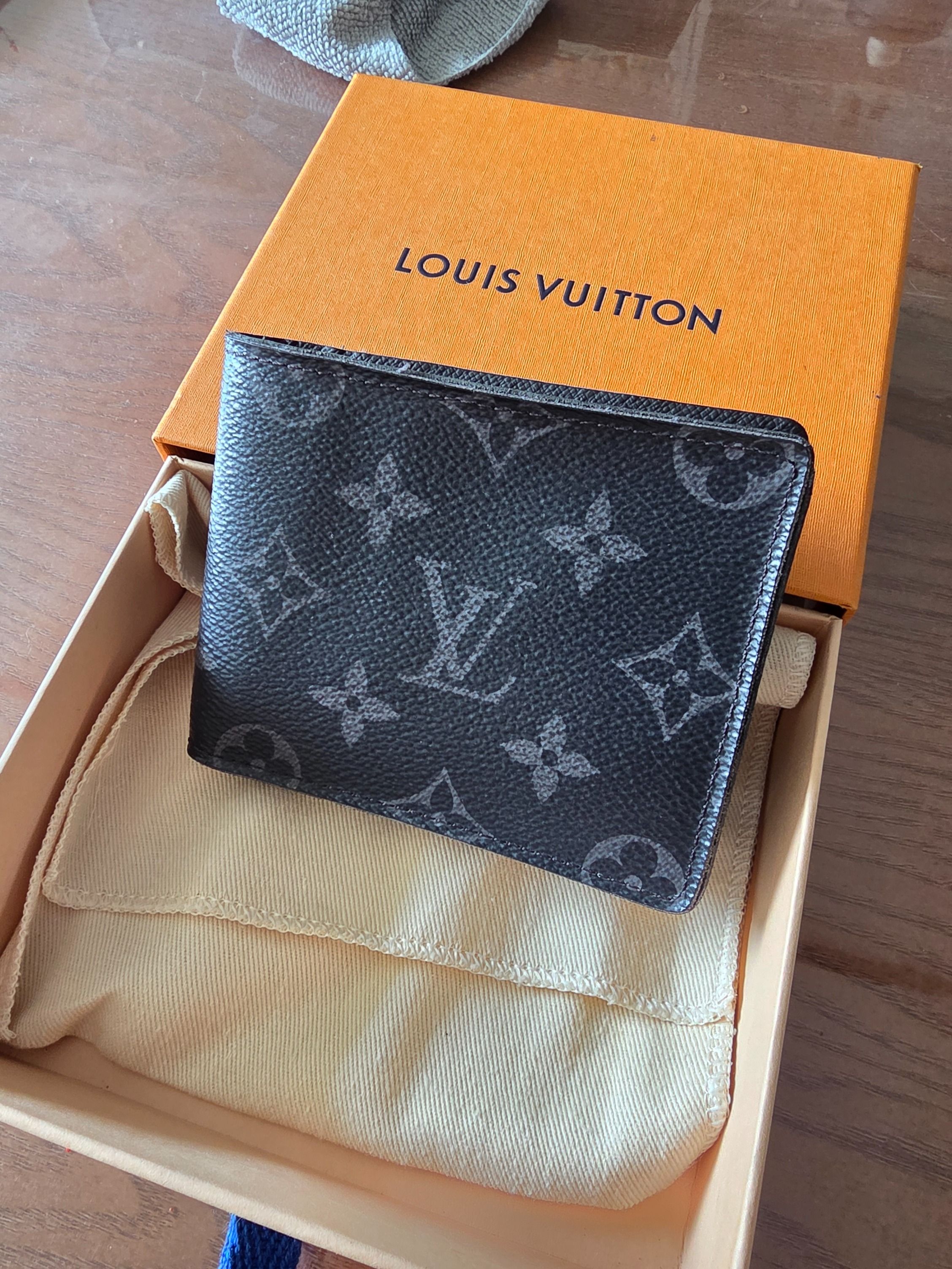 LV Multiple Wallet Monogram Eclipse (Category: Bags & Wallets) located in Singapore. Submitted by sean_neo (Listing ID 1460803731, Image 3). Description: - Brand: Louis Vuitton - Model: Multiple Wallet - Design: Monogram Eclipse canvas - Color: Black and grey - Features: Compact bifold design, multiple card slots - Condition: Well used with edge fraying, not for fussy buyer - Includes: Original Louis Vuitton box.