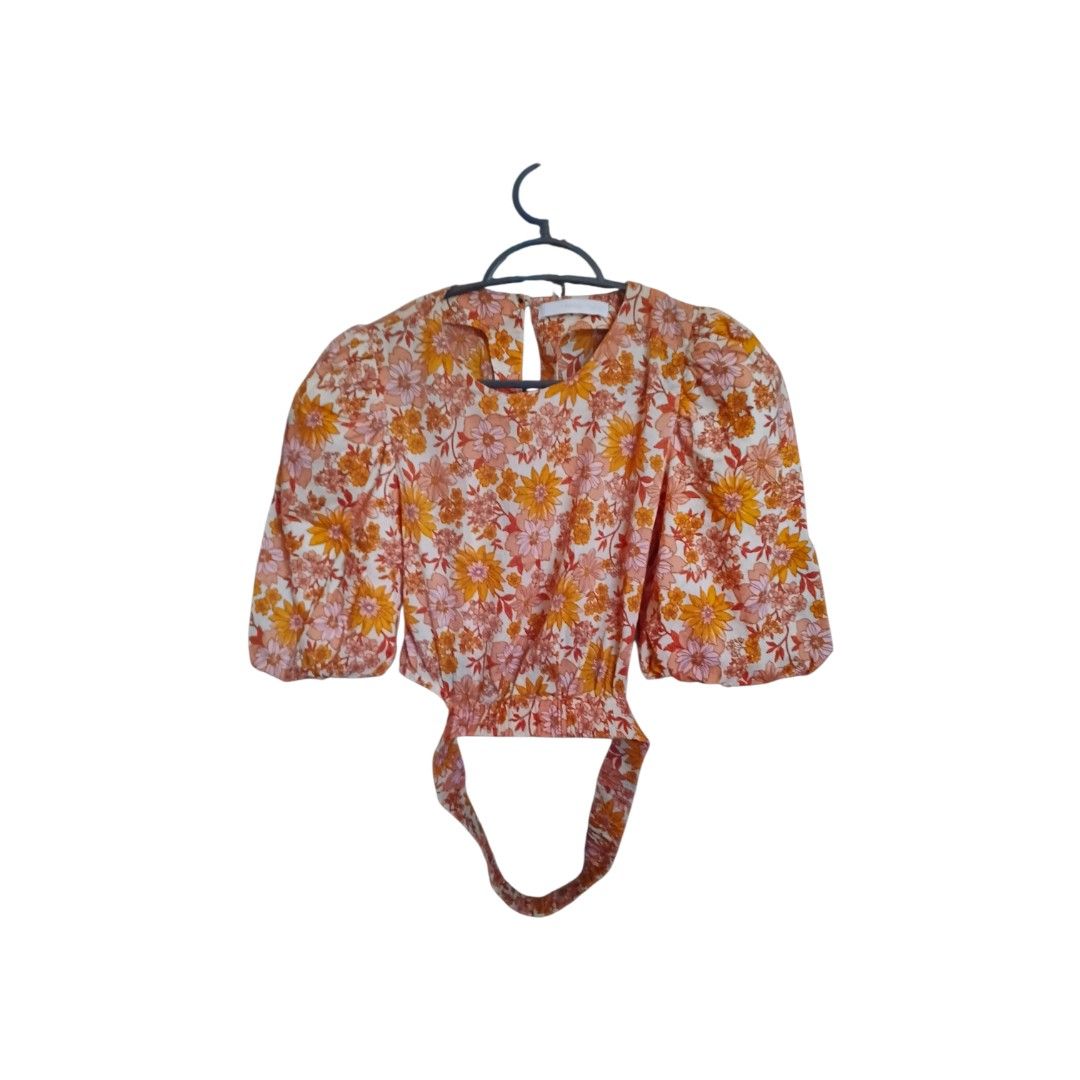 Mangl Floral Cropped Top (Category: Blouses) located in Quezon City. Submitted by pochac (Listing ID 1460832582, Image 1). Description: This floral crop top features a unique design with puff sleeves, elasticated waist, and keyhole back. The fabric is patterned with a mixture of orange, pink and white floral prints. It goes well with high-waist denims, trousers, bermuda shorts or skirts..