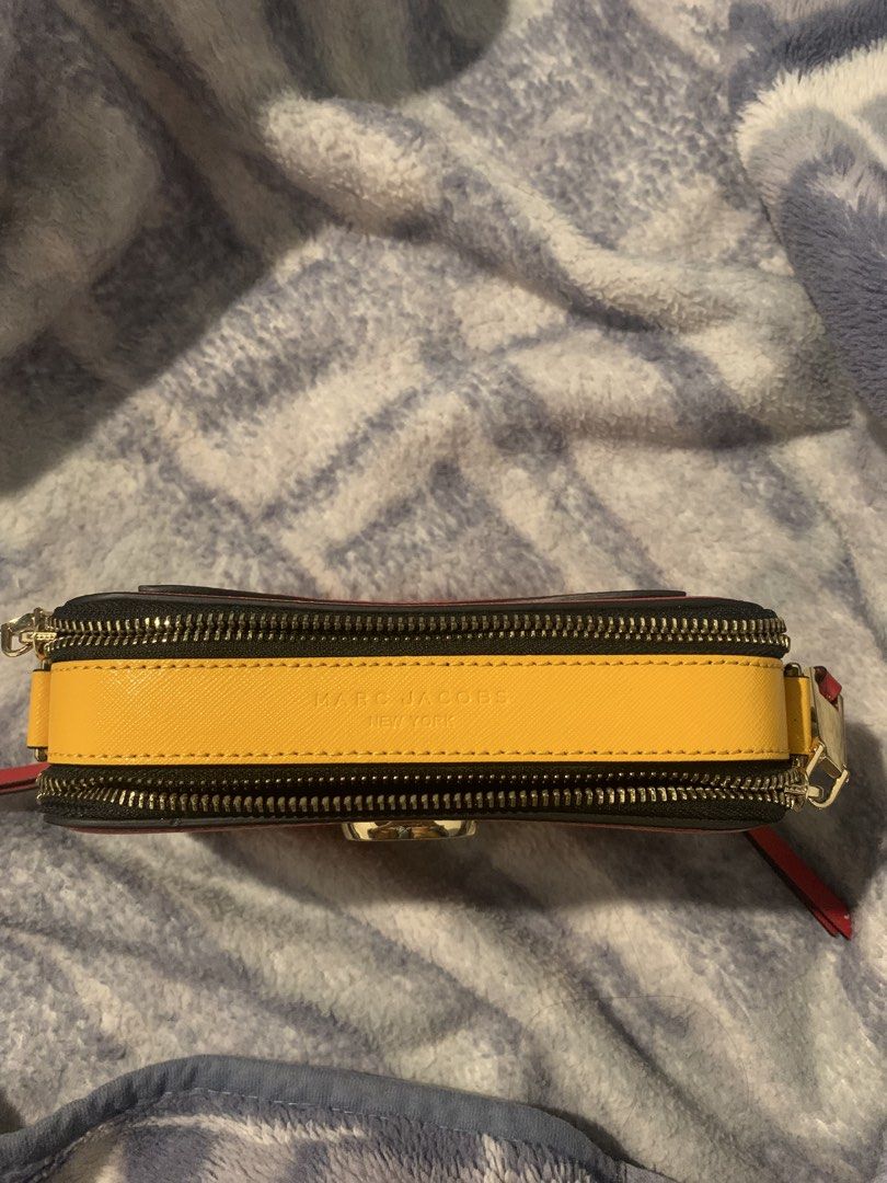 Marc Jacobs Snapshot Bag (Category: Luxury Bags & Wallets) located in Baguio. Submitted by daisear (Listing ID 1460793111, Image 2). Description: - Red Marc Jacobs camera bag - Gold hardware and signature MJ logo on the front - Unique yellow accent on the side - Secure zipper closure - Convenient back pocket - Comes with a detachable strap - Ideal for everyday wear and stylish outings Price is still negotiable .