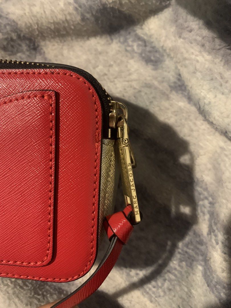 Marc Jacobs Snapshot Bag (Category: Luxury Bags & Wallets) located in Baguio. Submitted by daisear (Listing ID 1460793111, Image 3). Description: - Red Marc Jacobs camera bag - Gold hardware and signature MJ logo on the front - Unique yellow accent on the side - Secure zipper closure - Convenient back pocket - Comes with a detachable strap - Ideal for everyday wear and stylish outings Price is still negotiable .
