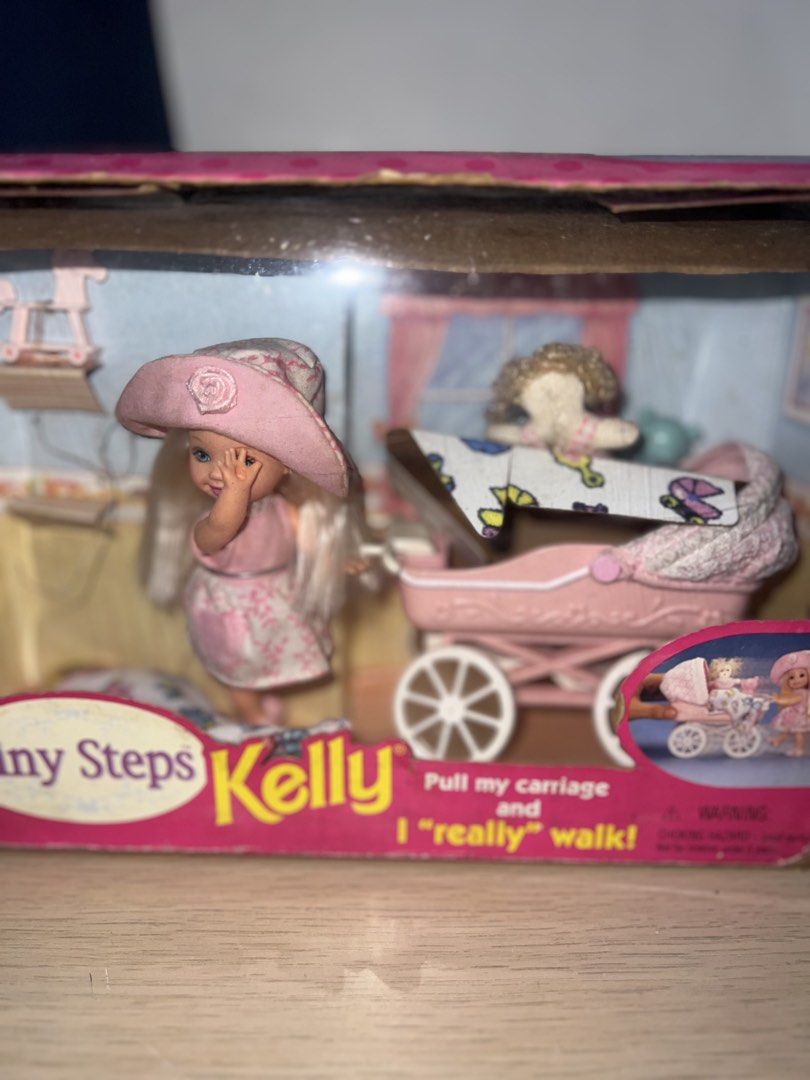 Mattel Kelly Tiny Steps Doll with Walking Carriage (Category: Kids Toys) located in Manila. Submitted by asa68984 (Listing ID 1460876076, Image 2). Description: - Mattel Kelly Tiny Steps doll set - Includes doll and pink carriage - Carriage is designed to 'walk' when pulled - Box shows some wear - Great for collectors or play.