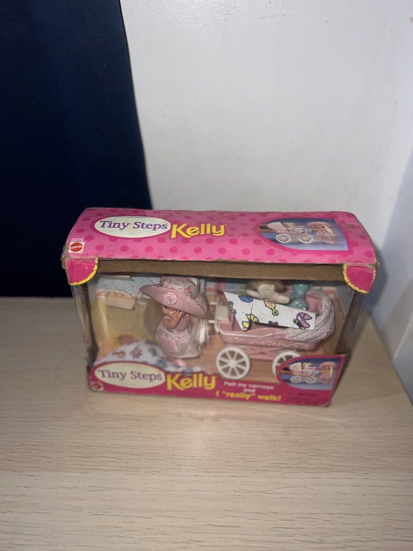Mattel Kelly Tiny Steps Doll with Walking Carriage (Category: Kids Toys) located in Manila. Submitted by asa68984 (Listing ID 1460876076, Image 3). Description: - Mattel Kelly Tiny Steps doll set - Includes doll and pink carriage - Carriage is designed to 'walk' when pulled - Box shows some wear - Great for collectors or play.