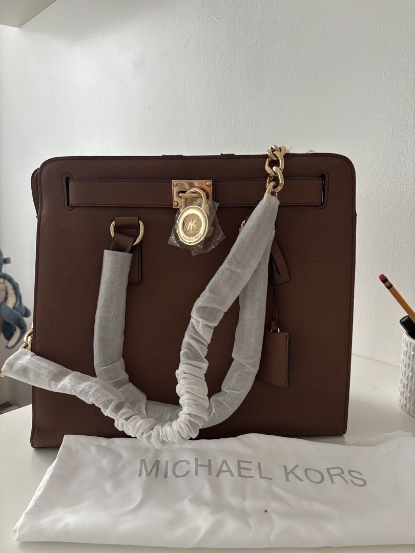 Michael Kors Brown Leather Satchel Handbag (Category: Luxury Bags & Wallets) located in Manila. Submitted by khloesmom (Listing ID 1460725484, Image 1). Description: - Authentic Michael Kors brown leather satchel - Elegant gold hardware with a secure lock detail - Spacious interior with multiple compartments for organization - Includes original dust bag for protection - Versatile design suitable for daily use or special events.