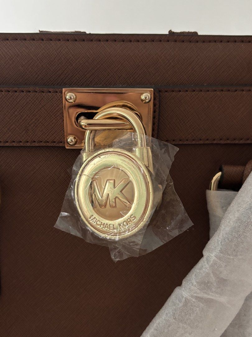 Michael Kors Brown Leather Satchel Handbag (Category: Luxury Bags & Wallets) located in Manila. Submitted by khloesmom (Listing ID 1460725484, Image 2). Description: - Authentic Michael Kors brown leather satchel - Elegant gold hardware with a secure lock detail - Spacious interior with multiple compartments for organization - Includes original dust bag for protection - Versatile design suitable for daily use or special events.