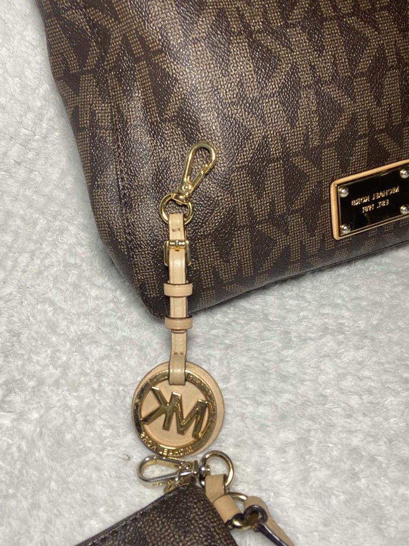 Michael Kors Monogram Handbag with Pouch (Category: Luxury Bags & Wallets) located in Baguio. Submitted by leah_rodrigo (Listing ID 1460760301, Image 2). Description: Authentic Michael Kors monogram handbag in brown. Includes a matching pouch. Features gold hardware and the iconic MK logo charm. Perfect for daily use or travel. Both bag and pouch showcase the signature MK pattern..