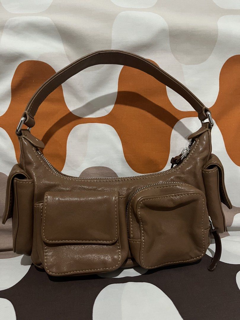 Miu Miu Brown Leather Pocket Bag (Category: Luxury Bags & Wallets) located in Las Pinas. Submitted by erenrosc (Listing ID 1460877074, Image 2). Description: - Miu Miu pocket bag in brown leather. - Multiple front pockets for convenient storage. - Secure top zipper closure. - Interior features Miu Miu logo and 'Made in Italy' tag. - Comfortable single shoulder strap. - Ideal for everyday wear. - With white and black tag - exterior zipper pullers 
