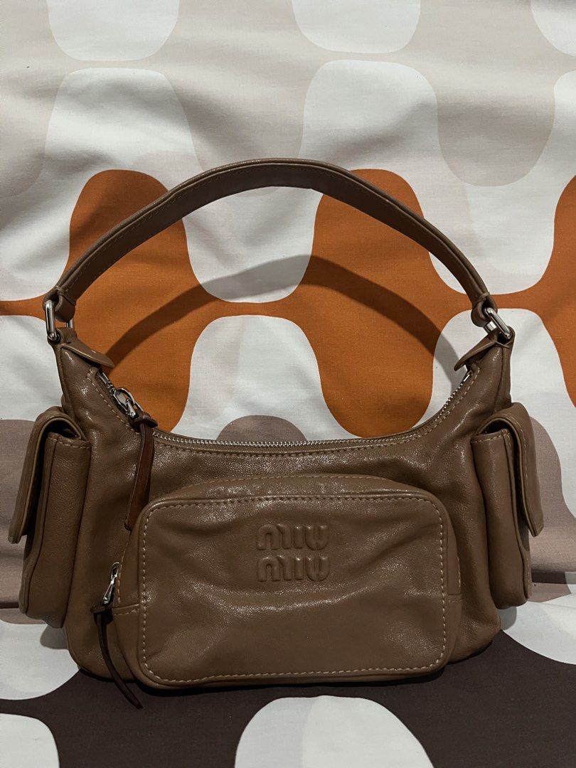 Miu Miu Brown Leather Pocket Bag (Category: Luxury Bags & Wallets) located in Las Pinas. Submitted by erenrosc (Listing ID 1460877074, Image 1). Description: - Miu Miu pocket bag in brown leather. - Multiple front pockets for convenient storage. - Secure top zipper closure. - Interior features Miu Miu logo and 'Made in Italy' tag. - Comfortable single shoulder strap. - Ideal for everyday wear. - With white and black tag - exterior zipper pullers 