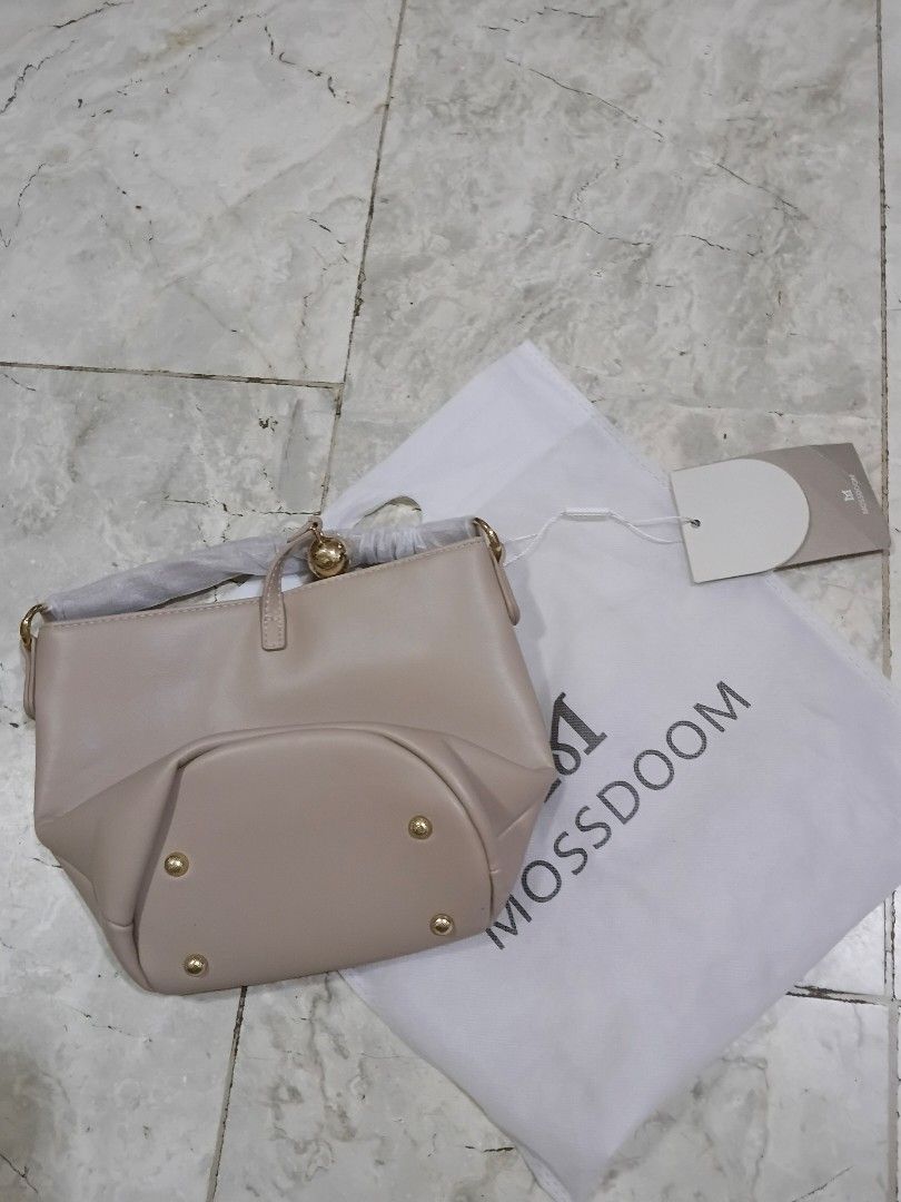 Mossdoom Beige Bucket Bag with Gold Hardware (Category: Shoulder Bags) located in Cavite. Submitted by ms.de.clutter (Listing ID 1460790409, Image 2). Description: - Brand: Mossdoom - Style: Bucket Bag - Color: Beige - Accents: Gold - Includes: Original dust bag and tags - Condition: New (handle still has protective plastic wrap) - Interior: Zippered pocket and slip pocket - Exterior: Protective studs on the bottom.
