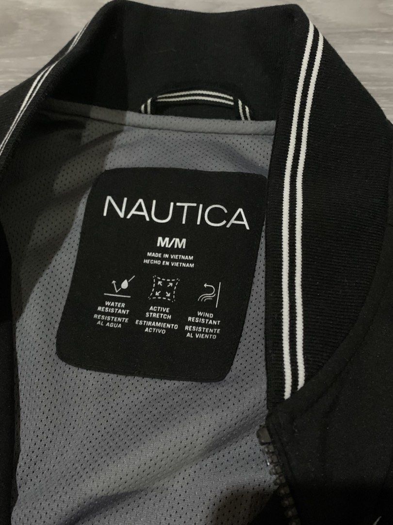 Nautica Bomber Jacket (Category: Coats, Jackets and Outerwear) located in Makati City. Submitted by bastiolarteee (Listing ID 1460869883, Image 2). Description: - Nautica Jacket - Color: Black - Size: Medium (M) - Features: Water resistant, wind resistant, active stretch material - Pockets: Zipped front pockets - Details: Ribbed collar and cuffs - Origin: Made in Vietnam.