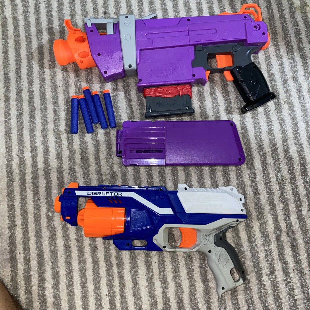 Nerf Fortnite DG and Elite Disruptor Blasters (Category: Action & Battle Toys) located in Pasig City. Submitted by eternalthreads.emporium (Listing ID 1460863230, Image 3). Description: - Two Nerf blasters included: Fortnite DG (purple) and Elite Disruptor (blue/white). - Fortnite DG comes with its magazine and some darts. - Both blasters are in working condition and ready for play. - Perfect for backyard battles, games, or adding to your Nerf co