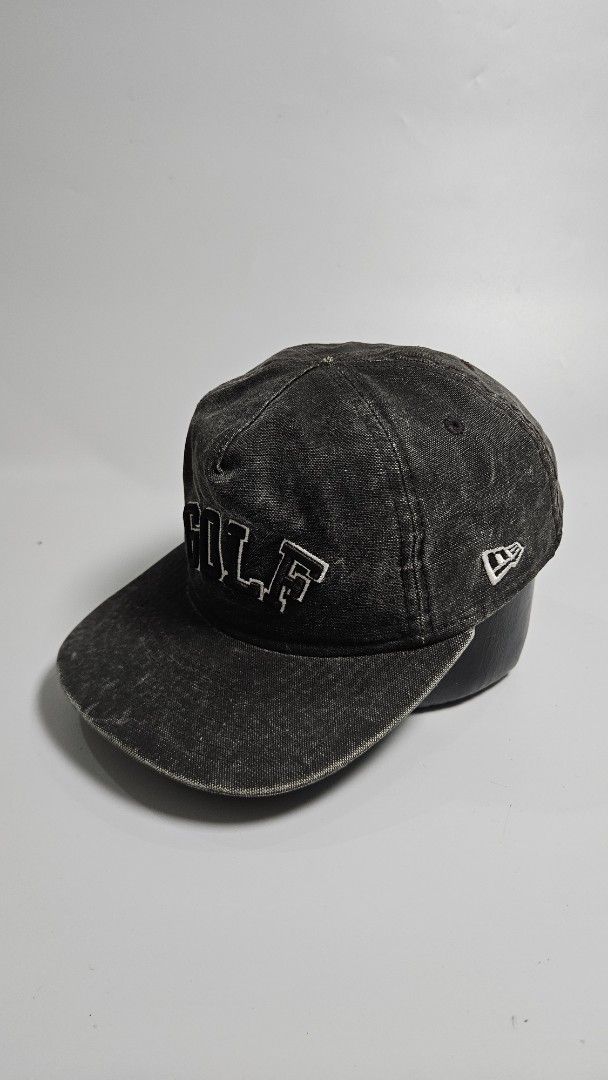 New Era Golf Snapback Cap (Category: Caps & Hats) located in Alfonso. Submitted by jbcamet (Listing ID 1460829929, Image 2). Description: - Black denim-look snapback cap - Features 'GOLF' embroidered in white on the front - New Era logo detail on the side - Adjustable snap closure for a custom fit - Ideal for casual outings or sports activities.