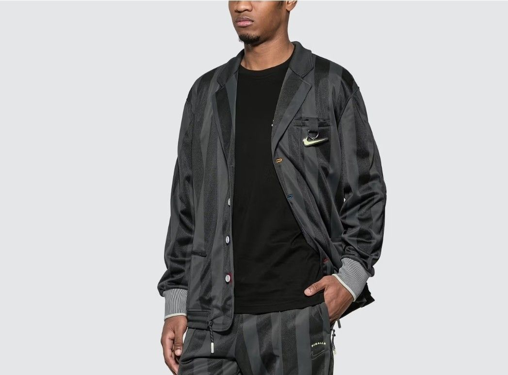 Nike x Pigalle Tracksuit Jacket (Category: Coats, Jackets and Outerwear) located in Las Pinas. Submitted by rcp123 (Listing ID 1460803449, Image 2). Description: - Best Fit medium to Large - 27 x 18 - Color may vary due to lighting - Eye-catching vertical stripes and colorful button details. - Signature Nike Swoosh logo for an authentic look. - Convenient zippered pockets on the sides. - Comfortable ribbed cuffs and hem. - Made from 100% polyeste