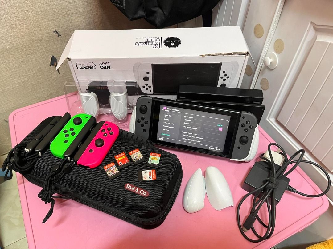 Nintendo Switch Console with Accessories and Games (Category: Nintendo) located in Manila. Submitted by fiery_lion03 (Listing ID 1460733017, Image 1). Description: Nintendo Switch V2 console Original dock Original charger/cables 2 pairs of Joy-Cons — gray + neon green/pink Carrying case (Skull & Co) Original box (Neo Grip) Joy-Con straps/accessories 5 physical games visible: Super Smash Bros. Ultimate NBA 2K22 Mario Party Superstars Animal Crossi