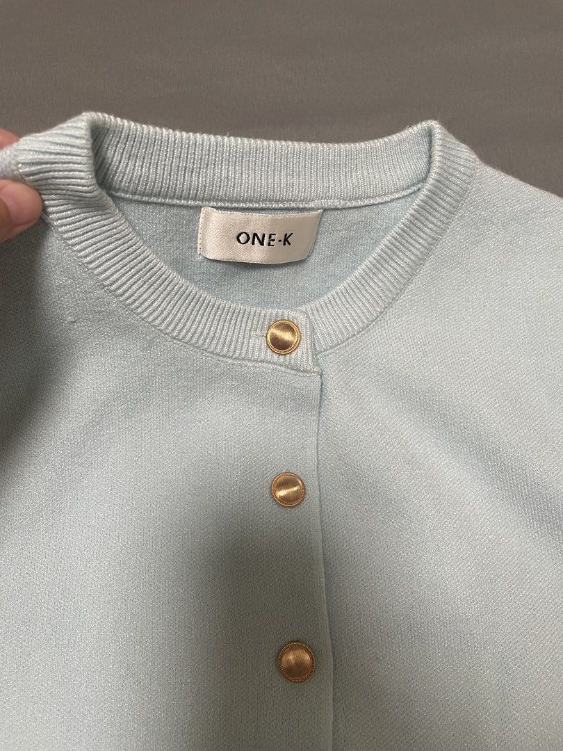 One K BKK Knit Cardigan (Category: Blouses) located in Quezon City. Submitted by mfordma (Listing ID 1460889432, Image 2). Description: BRAND NEW Originally bought for 590.00 Doing a little closet decluttering! ✨ Letting go of some pieces that are still in great condition and looking for a new home. 🤍 Brand: ONE-K Size: Free size Color: Light blue Description: - Short sleeve slightly stretchable cardigan - Features functional gold hardware down 