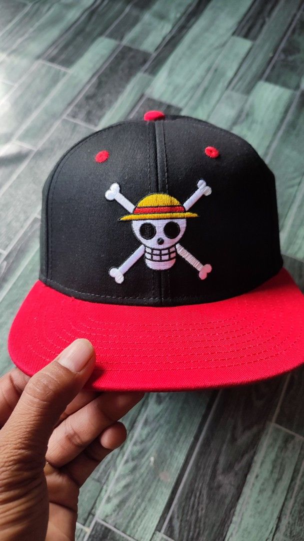 One Piece Straw Hat Pirates Snapback Cap (Category: Caps & Hats) located in Manila. Submitted by janyvony_315 (Listing ID 1460907234, Image 1). Description: - Black snapback cap with a striking red brim. - Features the iconic One Piece Straw Hat Pirates Jolly Roger logo embroidered on the front. - Red button on top and red eyelets for added detail. - Perfect for any dedicated One Piece fan! - Adjustable strap at the back for a comfortable, custom
