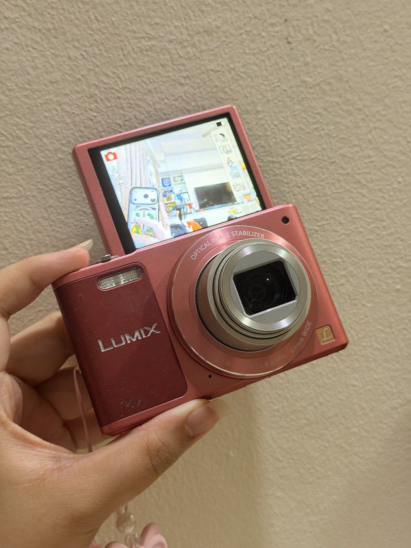Panasonic Lumix DMC SZ-10 Pink Digital Camera (Category: Cameras) located in Manila. Submitted by nikkitamarchei (Listing ID 1460815954, Image 1). Description: - Pink Panasonic Lumix digital camera - 12x optical zoom - Flip-up screen for easy viewing - Minor cosmetic scratches on screen, fully functional - Comes with battery, SD Card, and cute beaded strap - Ideal for everyday use and travel Bought for ₱15,000, selling for ₱12,000 (price is negot