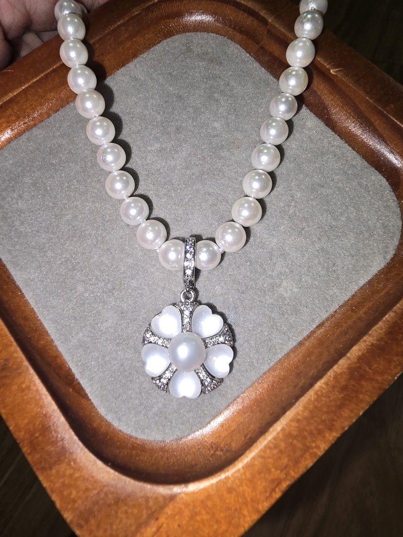 Pearl Necklace with Flower Pendant (Category: Necklaces) located in Santa Rosa. Submitted by crystal1.0 (Listing ID 1460773020, Image 1). Description: - Beautiful pearl necklace - Unique flower-shaped pendant with pearl center - Pendant adorned with smaller stones and heart-shaped petals - Delicate, silver-toned chain - Versatile accessory to elevate any outfit - Ideal for gifting.