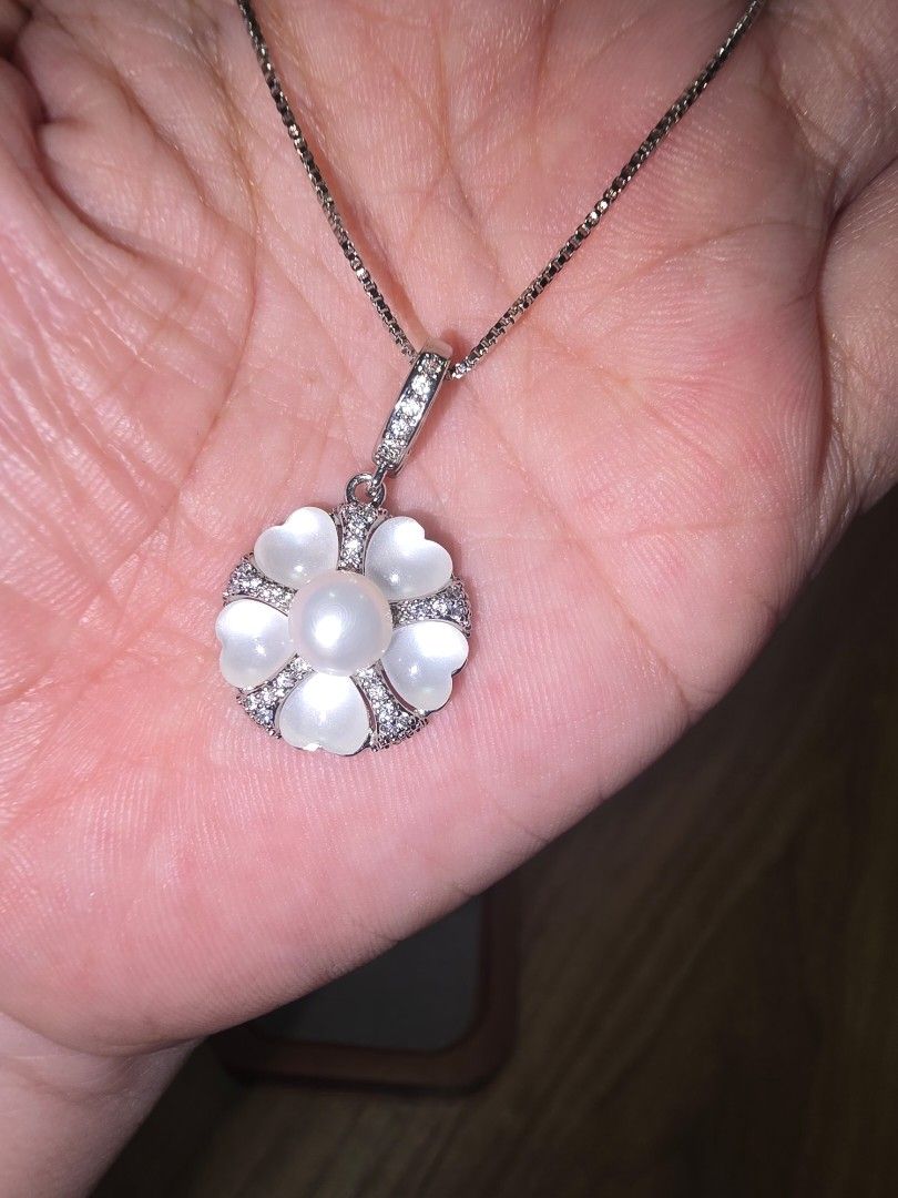 Pearl Necklace with Flower Pendant (Category: Necklaces) located in Santa Rosa. Submitted by crystal1.0 (Listing ID 1460773020, Image 3). Description: - Beautiful pearl necklace - Unique flower-shaped pendant with pearl center - Pendant adorned with smaller stones and heart-shaped petals - Delicate, silver-toned chain - Versatile accessory to elevate any outfit - Ideal for gifting.