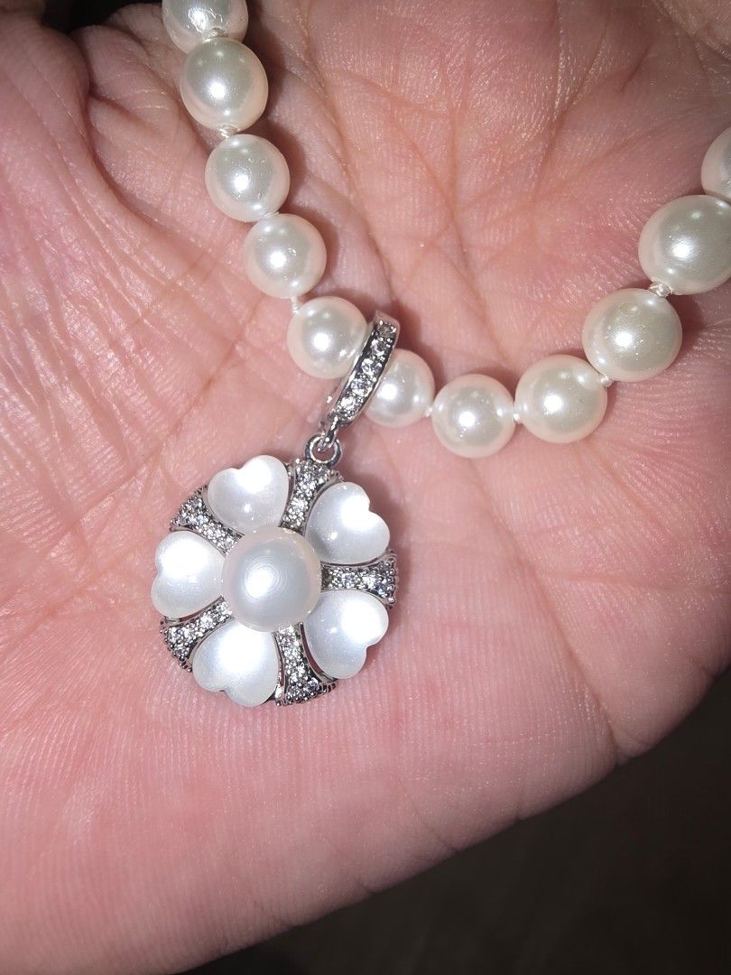 Pearl Necklace with Flower Pendant (Category: Necklaces) located in Santa Rosa. Submitted by crystal1.0 (Listing ID 1460773020, Image 2). Description: - Beautiful pearl necklace - Unique flower-shaped pendant with pearl center - Pendant adorned with smaller stones and heart-shaped petals - Delicate, silver-toned chain - Versatile accessory to elevate any outfit - Ideal for gifting.