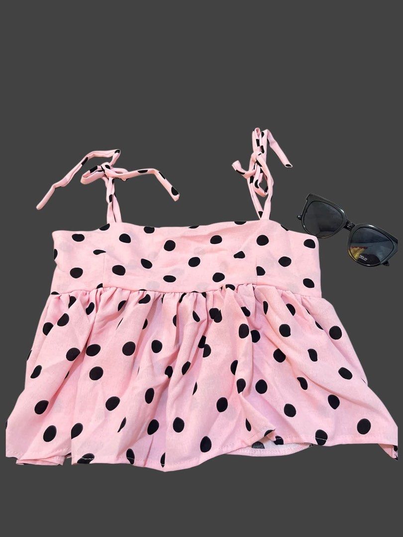 Pink Polka Dot Tie Strap Top (Category: Sleeveless) located in Cabuyao City. Submitted by mayannggajduaknzb55 (Listing ID 1460718978, Image 1). Description: - Adorable pink top with classic black polka dots. - Features adjustable tie straps on the shoulders for a perfect fit. - Trendy ruffled hemline adds a feminine touch. - Made from lightweight, flowy fabric for ultimate comfort. - Ideal for casual wear, beach days, or a relaxed vibe. - Effortl