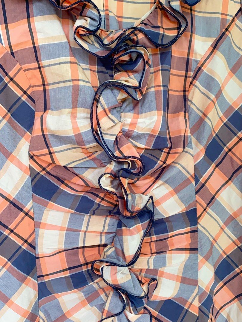 PLAID RUFFLE BLOUSE (Category: Blouses) located in Naga. Submitted by willowjuls (Listing ID 1460742121, Image 3). Description: The cutest mix of preppy + Y2K + vintage girlie! 🍑💙 ♡ Peach, navy & cream plaid ♡ Dramatic cascading front ruffles ♡ Ruffle collar ♡ Short sleeves ♡ Elasticated hem ♡ Lightweight fabric Size S-M No major flaws noted unless stated above..