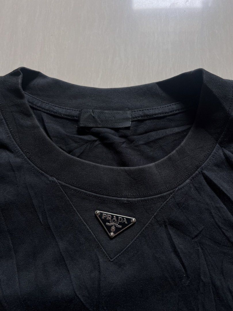 Prada Black T-Shirt with Triangle Logo (Category: Tshirts & Polo Shirts ) located in Zamboanga. Submitted by safe.haimer (Listing ID 1460841748, Image 2). Description: - Prada black t-shirt -size L30 W26 - Features the signature Prada triangle logo on the chest - Classic and versatile design - Ideal for casual, everyday styling.