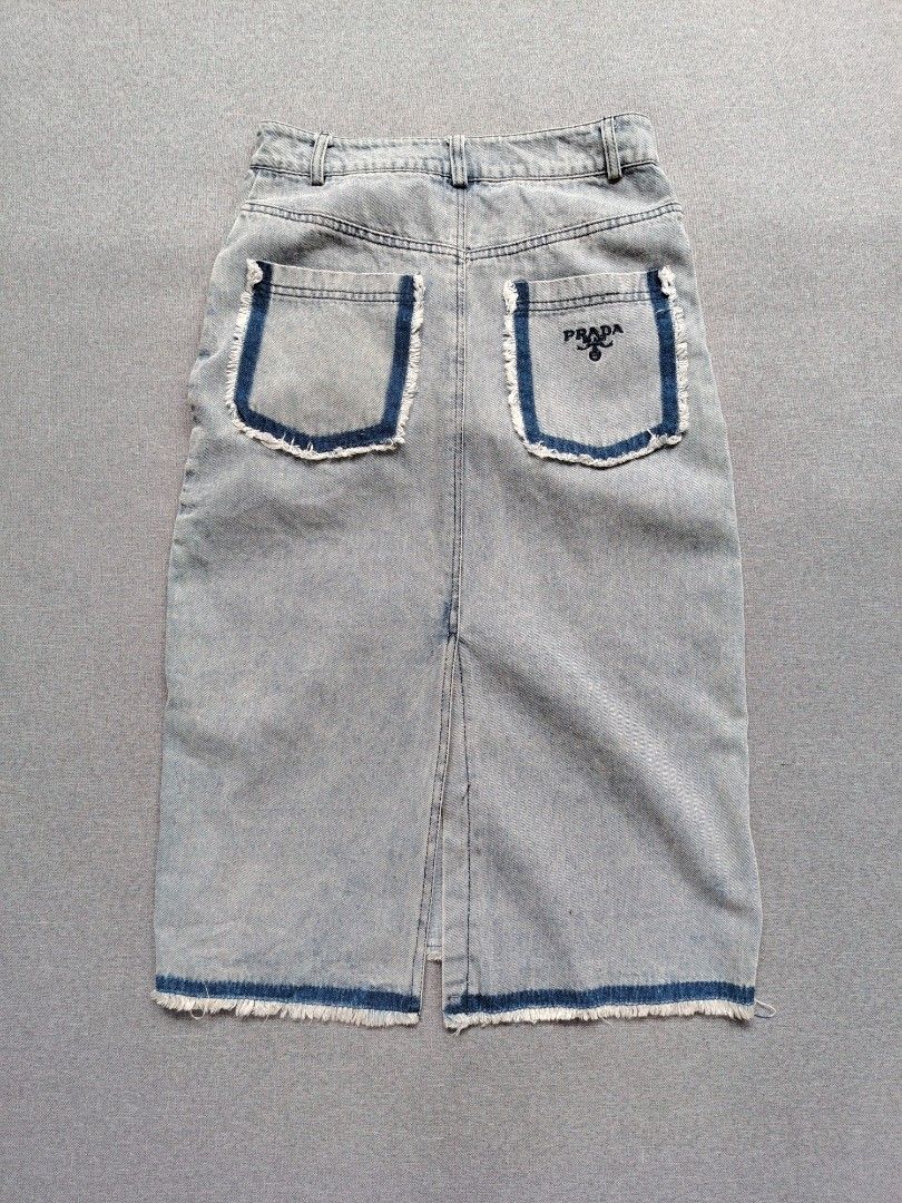 Prada Denim Midi Skirt (Category: Skirts) located in Taguig. Submitted by _theroom.ph (Listing ID 1460771149, Image 2). Description: - Authentic Prada light wash denim midi skirt - Features iconic Prada triangle logo on front pocket - Stylish frayed hem detail - Classic five-pocket styling - Secure button and zip closure - Ideal for everyday casual wear Prada Denim Midi Skirt Size 36 On Tags Fits 27 Womens Length : 28.5 Excellent Condition 1500 +