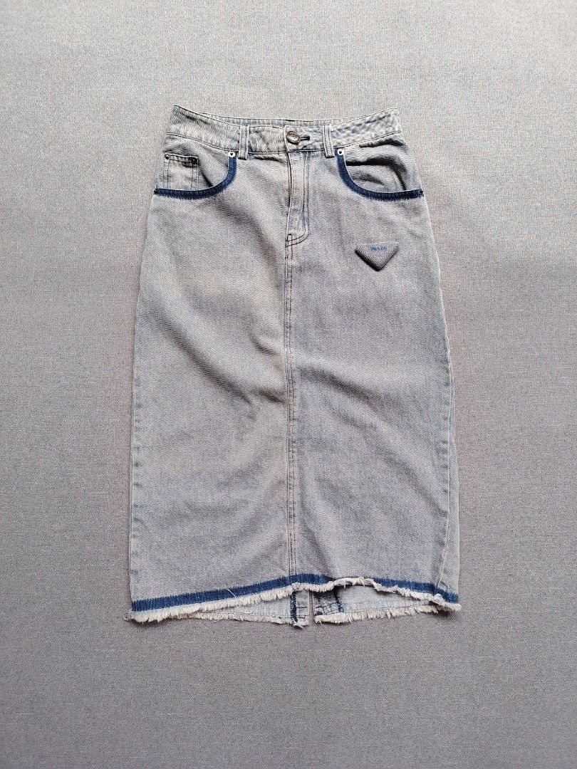 Prada Denim Midi Skirt (Category: Skirts) located in Taguig. Submitted by _theroom.ph (Listing ID 1460771149, Image 1). Description: - Authentic Prada light wash denim midi skirt - Features iconic Prada triangle logo on front pocket - Stylish frayed hem detail - Classic five-pocket styling - Secure button and zip closure - Ideal for everyday casual wear Prada Denim Midi Skirt Size 36 On Tags Fits 27 Womens Length : 28.5 Excellent Condition 1500 +