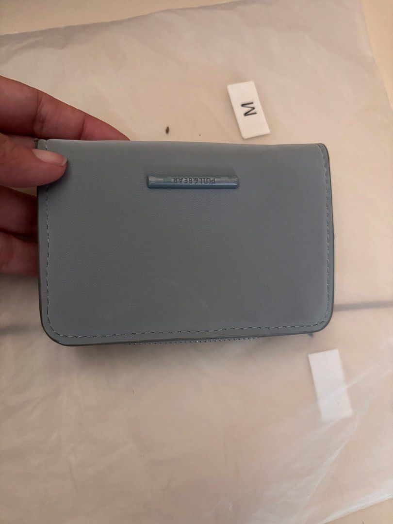 Pull & Bear Blue Bi-fold Wallet (Category: Wallets & Card holders) located in Pasig City. Submitted by bookishnook (Listing ID 1460771939, Image 1). Description: - Cute blue wallet from Pull & Bear - Features card slots - Includes a coin compartment with a zip - Secure snap button closure - Small and compact design, fits easily in any bag - Ideal for everyday use.
