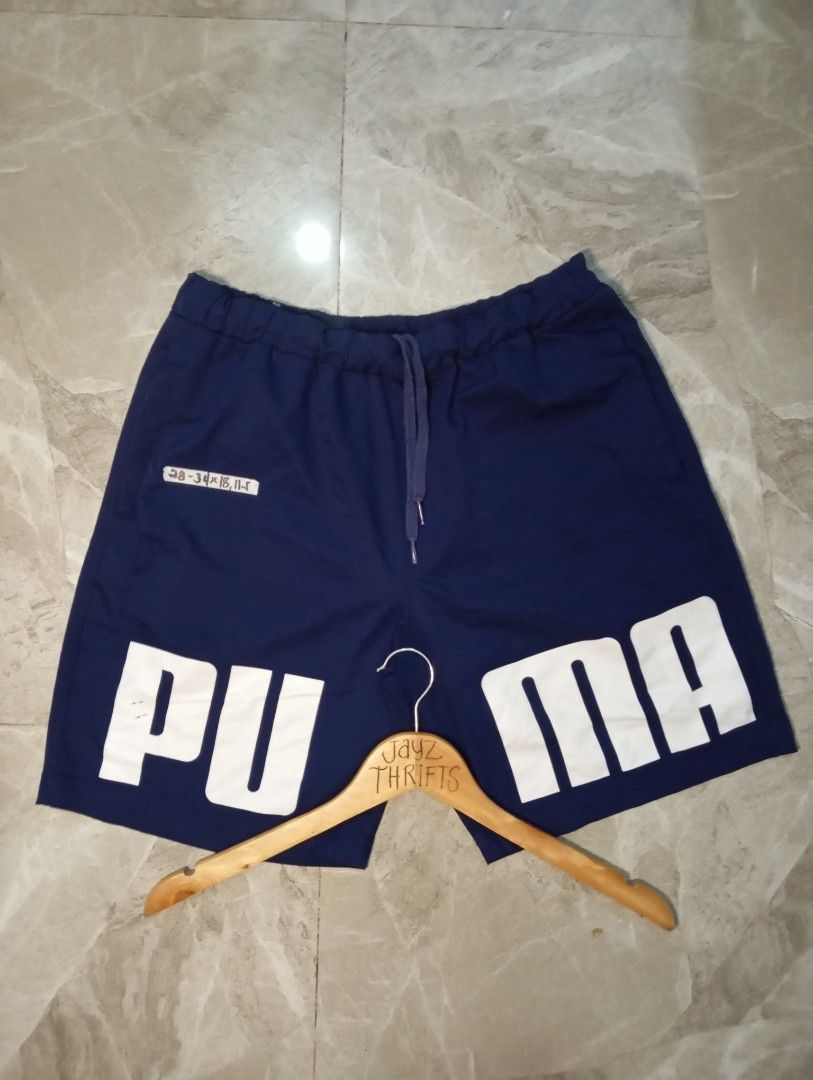 Puma Navy Blue Athletic Shorts Size M (Category: Activewear) located in Quezon City. Submitted by ThriftsPaMore (Listing ID 1460837065, Image 1). Description: - Navy blue Puma Big Script Lightweight shorts - Large Puma logo on left leg - Elastic waistband with drawstring - Pockets included - Size Medium 28-34*18, 11.5 - Ideal for sports or casual wear - 9.5/10 Color Rate - Very Good Condition -Issue: please do check pics, 2Cracks on "P" ; tolerab
