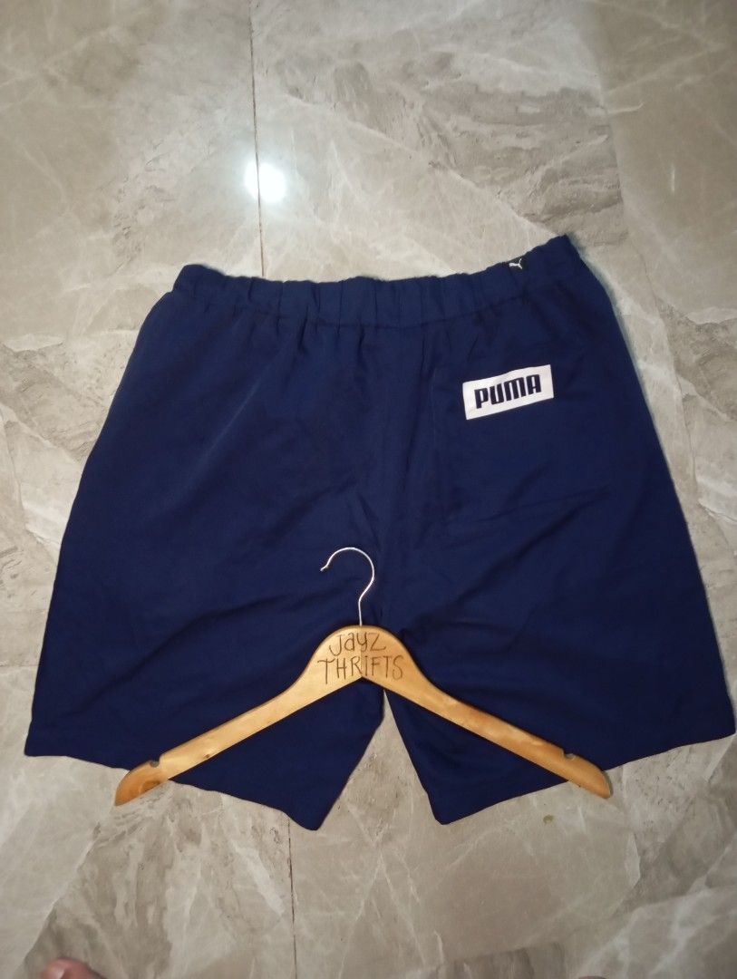 Puma Navy Blue Athletic Shorts Size M (Category: Activewear) located in Quezon City. Submitted by ThriftsPaMore (Listing ID 1460837065, Image 2). Description: - Navy blue Puma Big Script Lightweight shorts - Large Puma logo on left leg - Elastic waistband with drawstring - Pockets included - Size Medium 28-34*18, 11.5 - Ideal for sports or casual wear - 9.5/10 Color Rate - Very Good Condition -Issue: please do check pics, 2Cracks on "P" ; tolerab