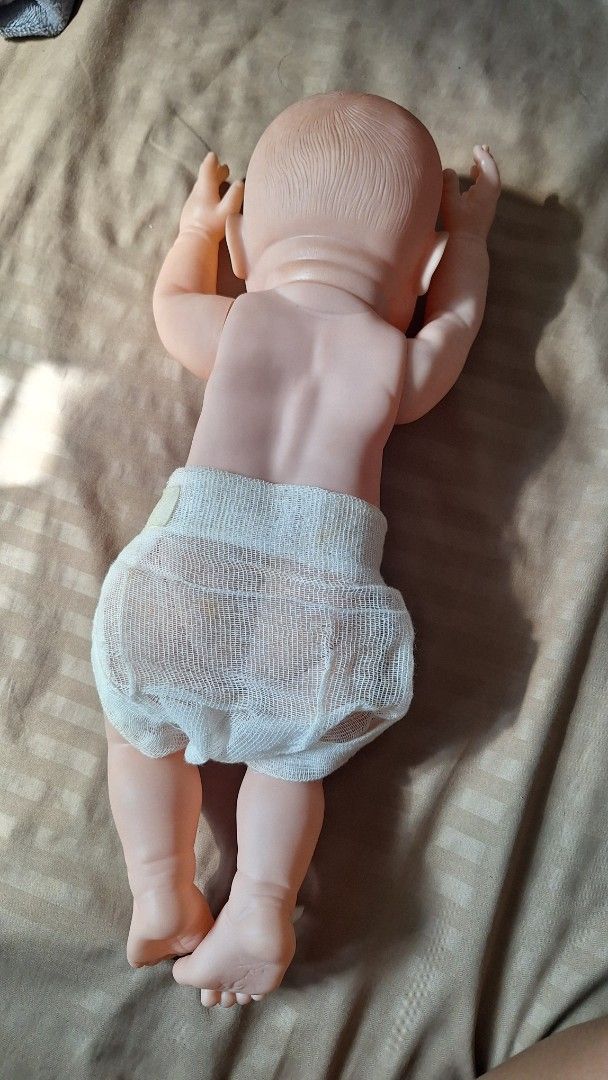 Realistic Baby Doll (Category: Kids Toys) located in San Ildefonso. Submitted by softstepsriri (Listing ID 1460771326, Image 3). Description: - Lifelike baby doll, approximately 18 inches long. - Features striking blue eyes and an open mouth. - Poseable limbs for realistic positioning. - Realistic skin texture for an authentic feel. - Ideal for both play and display - Good for return demonstration practice! purposes..