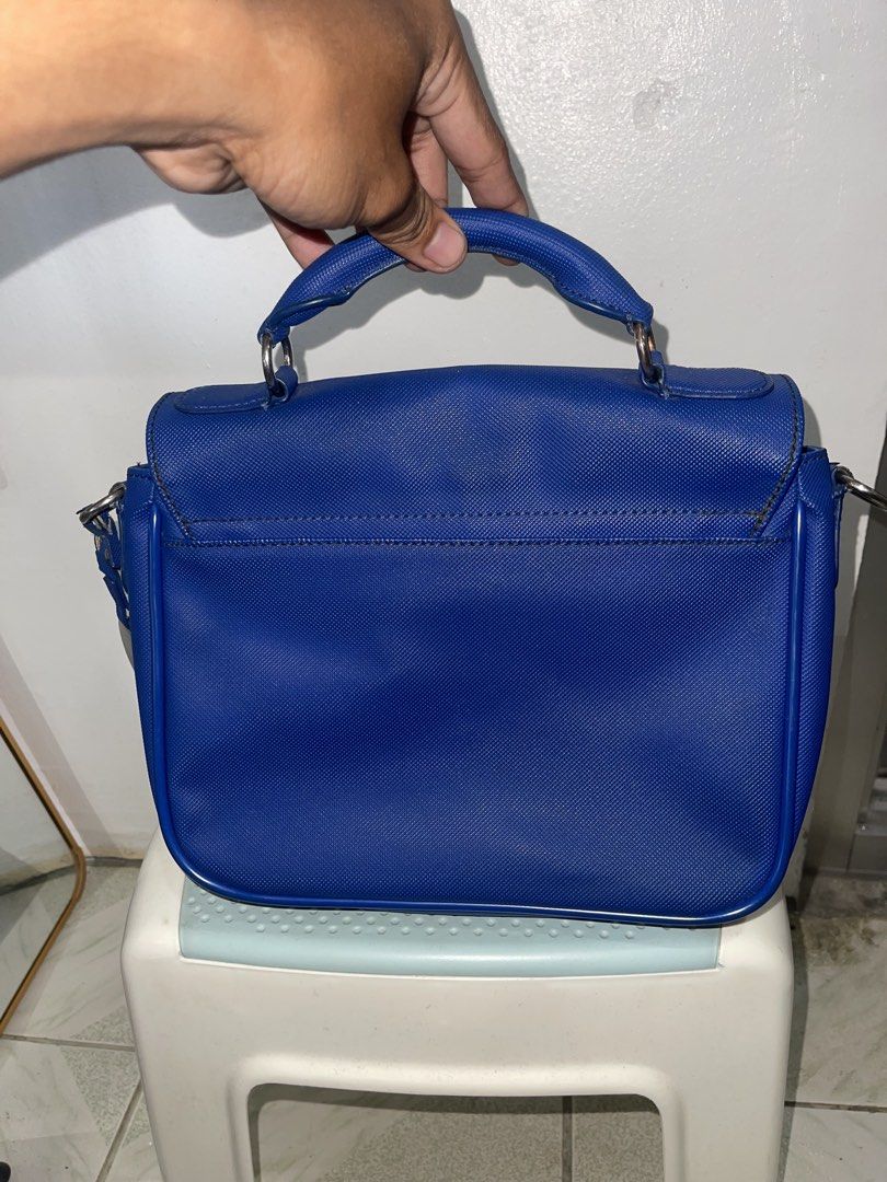 royal blue Lacoste crossbody bag (Category: Luxury Bags & Wallets) located in Manila. Submitted by john_robert00 (Listing ID 1460890384, Image 2). Description: royal blue Lacoste crossbody bag Issue : crack leather sa loob pm sa details. .